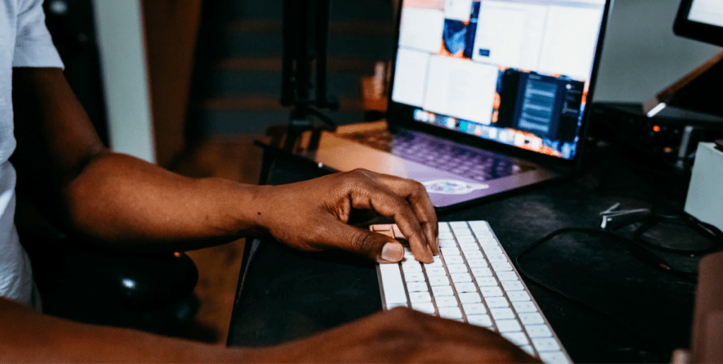 Black man on computer looking to find quality content writers online. Keep reading to learn where to find blog writers and quality freelance content writers for your blog.