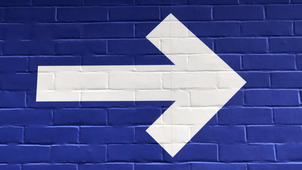 A white arrow on a blue background pointing to the left, representing website conversion rate. Keep reading to learn more about how you can increase website conversions.
