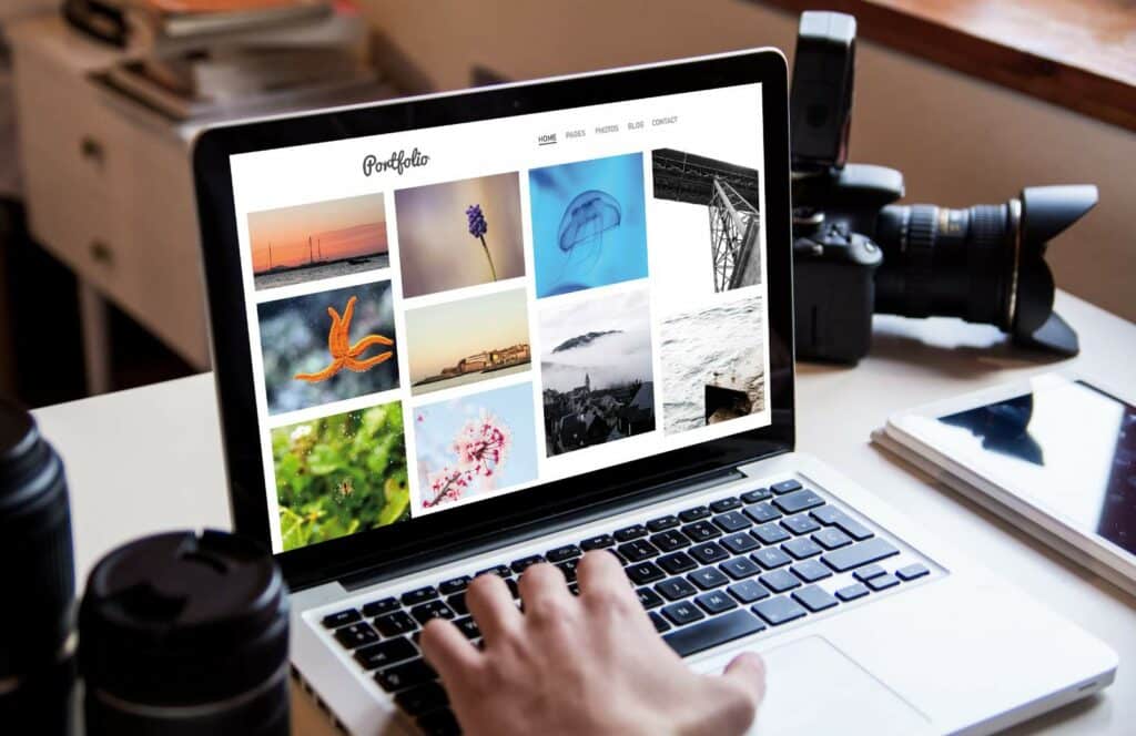 A laptop showing a photography portfolio site on a website, which can help the photographer make money blogging. Read for more tips on how to monetize your blog from day one.