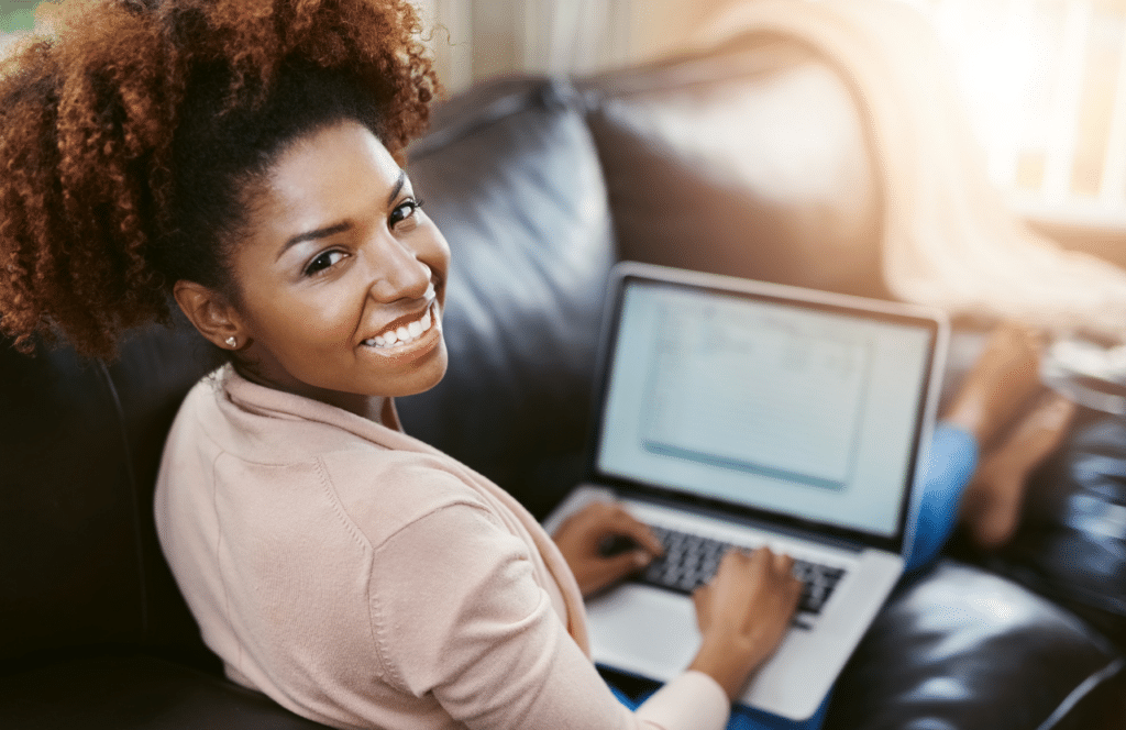 A black woman sitting on the couch working on her blog with the goal of becoming a full-time blogger. Keep reading to learn the answer to the question, "Is Blogging Still Relevant?"