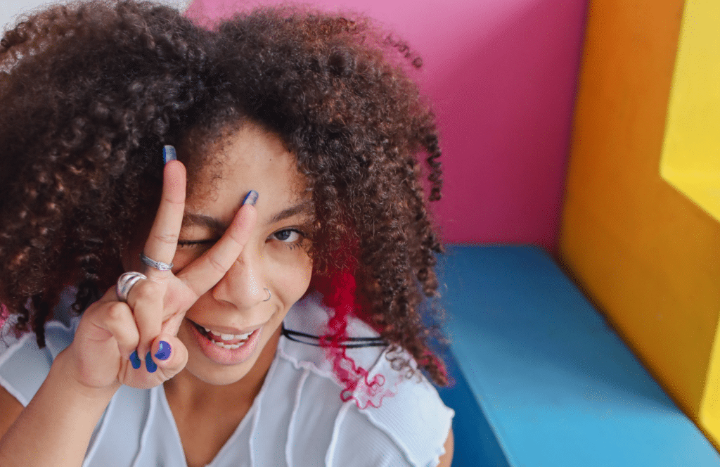 A Black woman throwing up a peace sign because she just left her full-time job to be a full-time blogger. Keep reading to learn the answer to the question, "Is Blogging Still Relevant?"