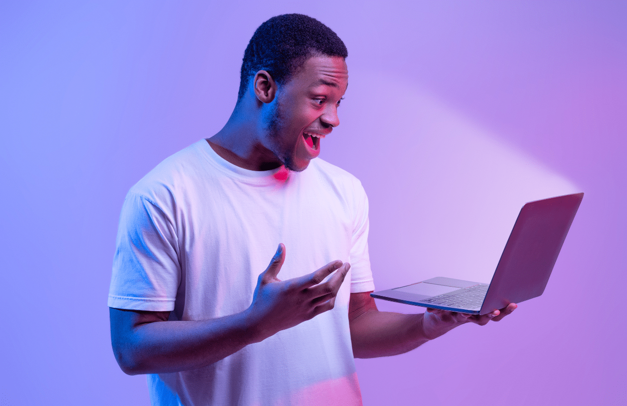 A man with a surprised face looking at his laptop.