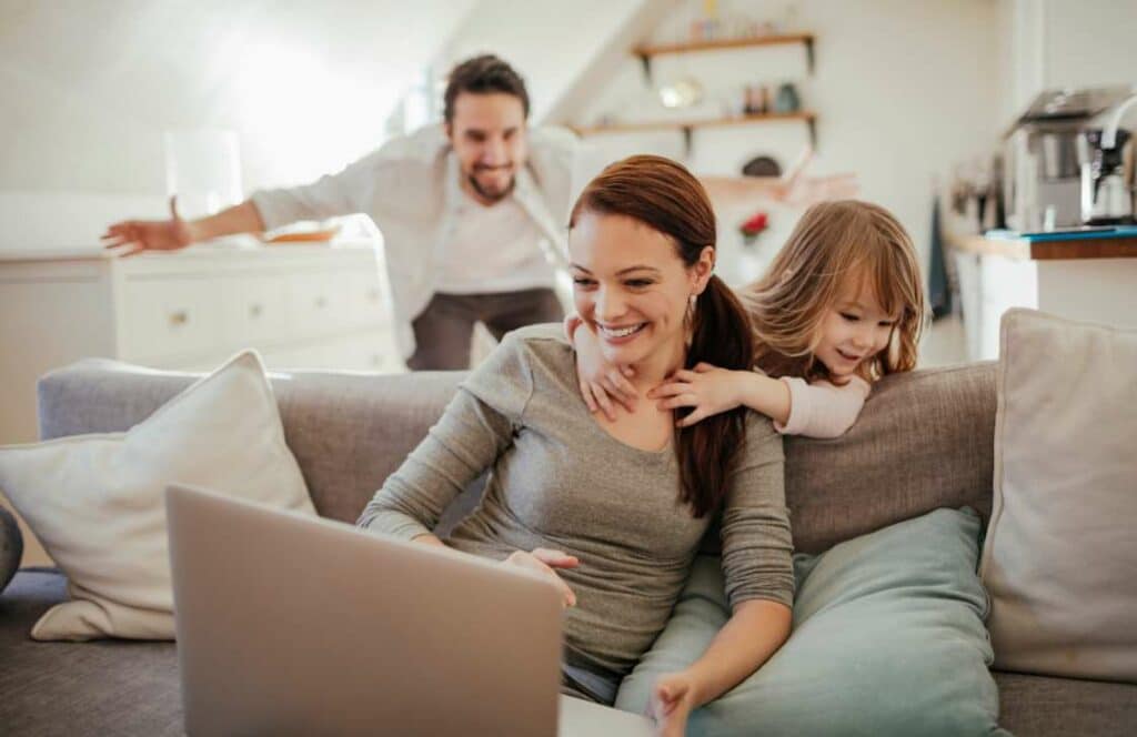 A mom blogger spending time with her family in the living room on the couch. If you've ever asked "What's the point of blogging?" click here to read more.