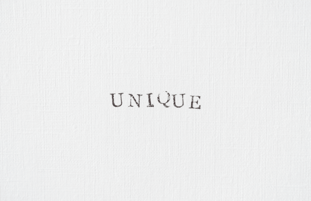 A textured background with the word "unique" typed in all capital letters. Keep reading to learn the answer to the question, "Is Blogging Still Relevant?"