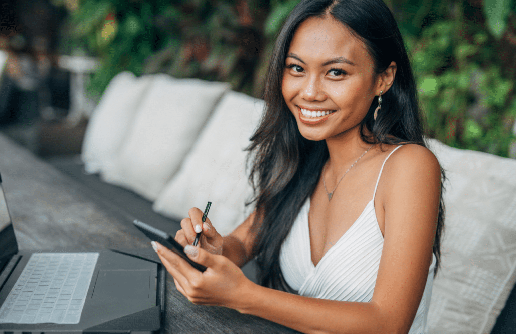 A woman blogger, who is smiling because she is passionate about what she does. Keep reading to learn the answer to the question, "Is Blogging Still Relevant?"