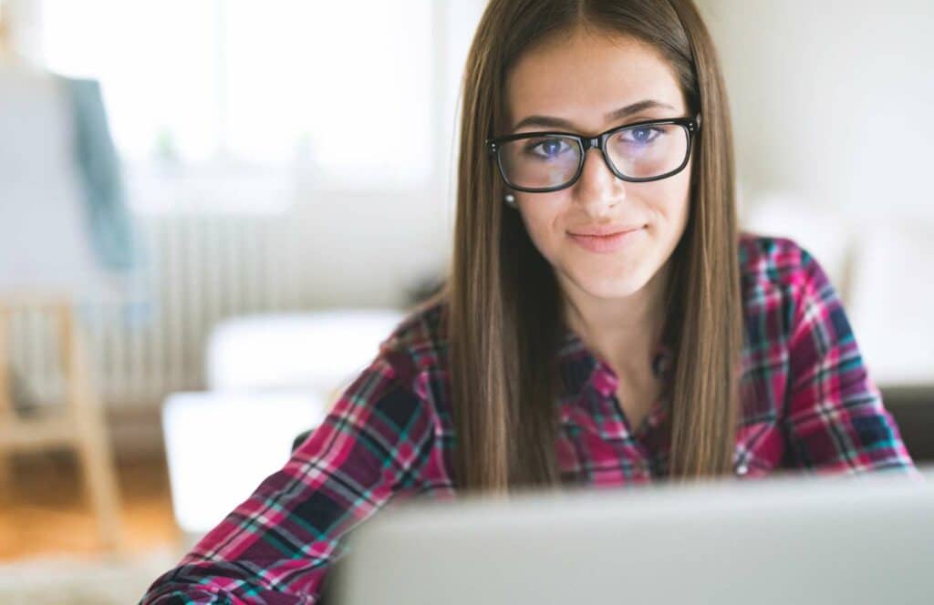 A woman with black glasses sitting at a desk and concentrating while working on her blog linking strategy. Learn more about internal linking best practices by reading this blog post.
