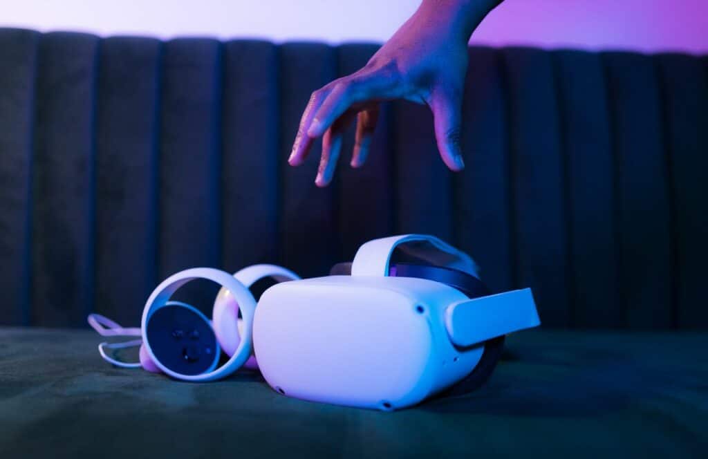 Personal grabbing an AR/VR occulus off of the sofa in a room with purple lighting. Learn more about how our lives shift to the digital world, content will only grow in importance because content is king.