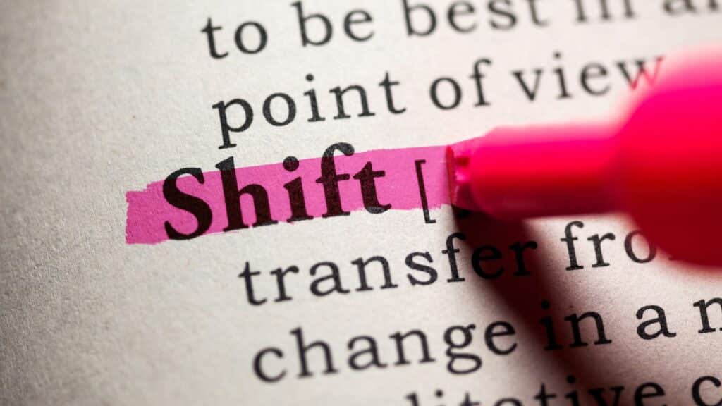 A hot pink highlighter coloring the word shift in dictionary. Click here to learn more about affiliate vs partner marketing for bloggers.