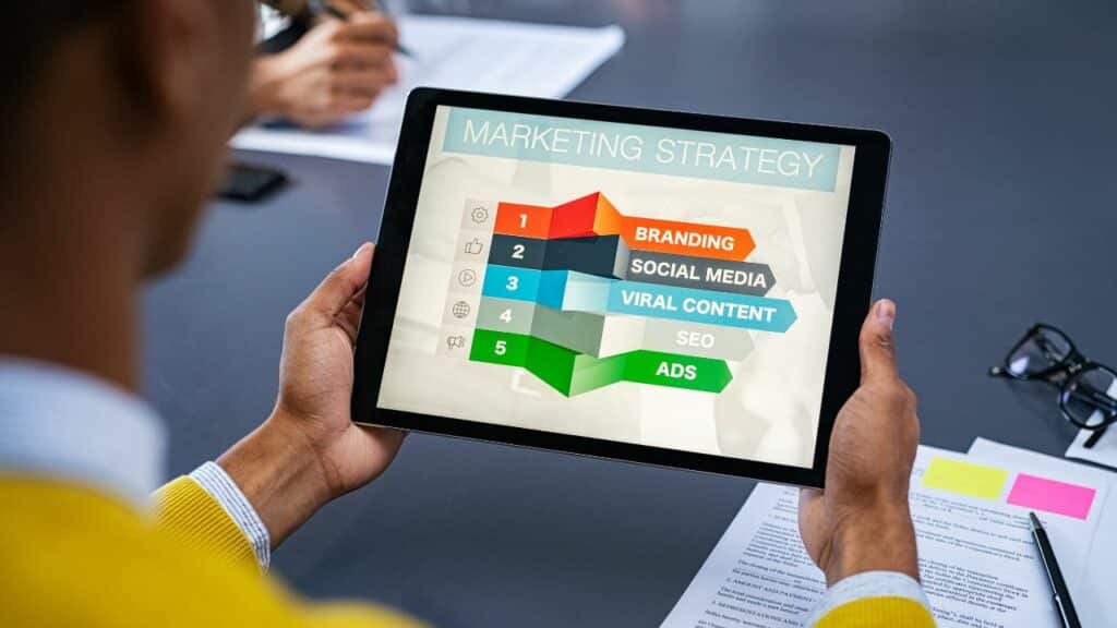 A person using a tablet PC to analyze data and create a marketing plan. Click here to learn more about affiliate vs partner marketing for bloggers.
