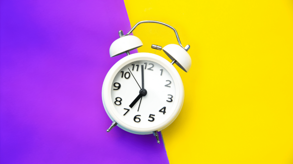 A timer clock on a purple and white background. Keep reading to understand how to save time writing the ideal length for a blog post.